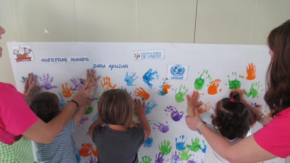 Alumnos de Infantil de la escuela de Barbastro plasman sus manos sobre el mural.