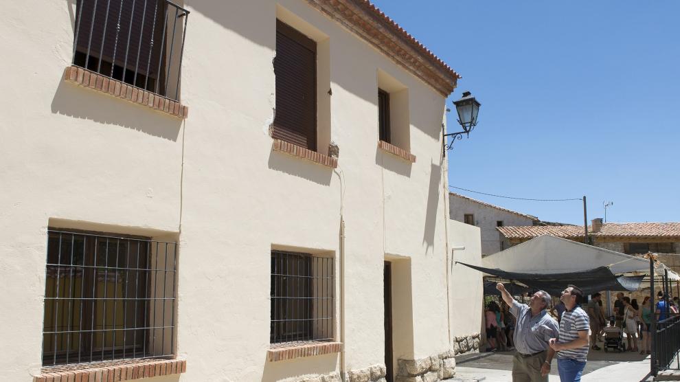 Dos vecinos de Villarroya de los Pinares observan el balcón desde el que cayó el joven.