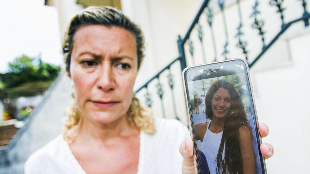 La madre de la joven desaparecida muestra su fotografía.