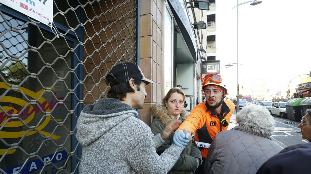 Jonathan Babiano, con un miembro del 061 y otros vecinos del inmueble afectado por la explosión de gas en Tenor Fleta.