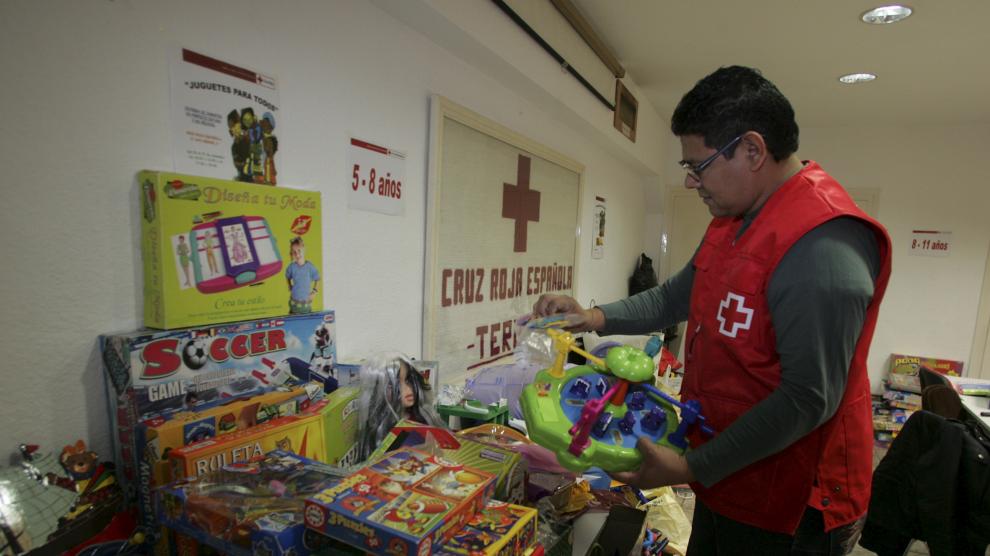 Un voluntario de Cruz Roja almacena los juguetes recogidos.