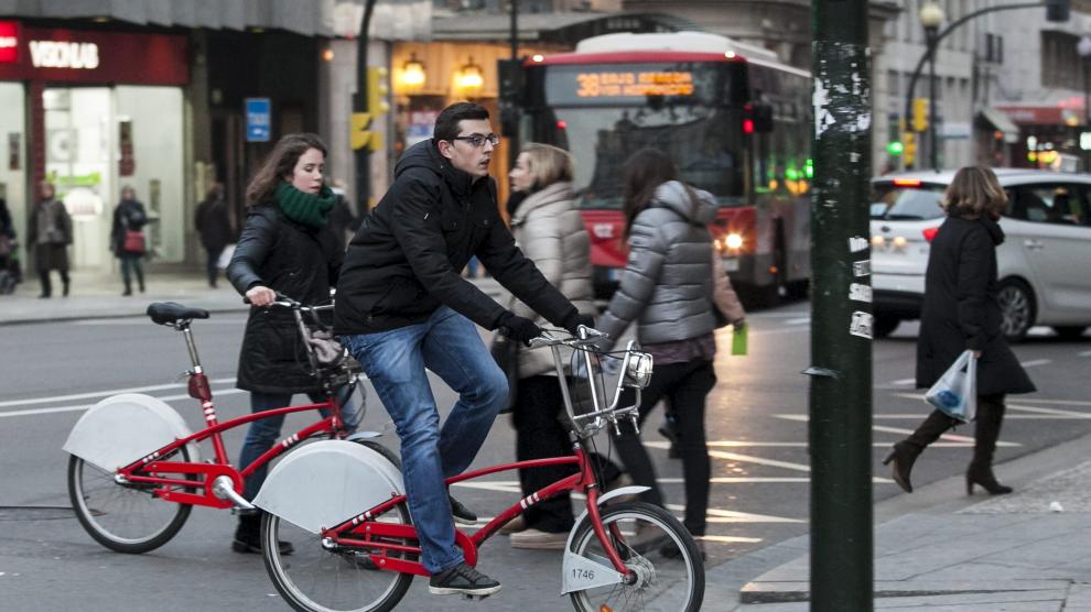 Dos usuarios del servicio público de bicicletas de alquiler Bizi, en el Coso de Zaragoza