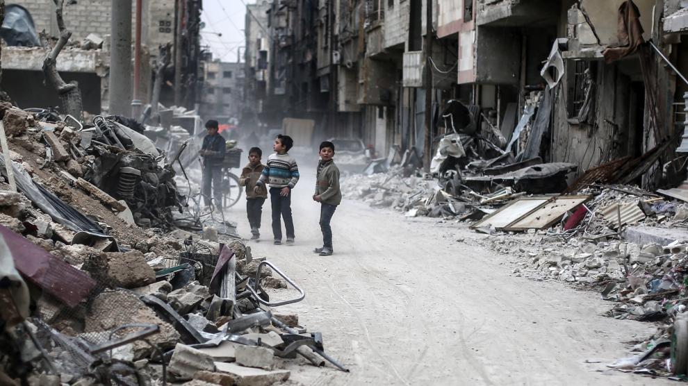 Varios niños sirios buscan entre los escombros de Alepo