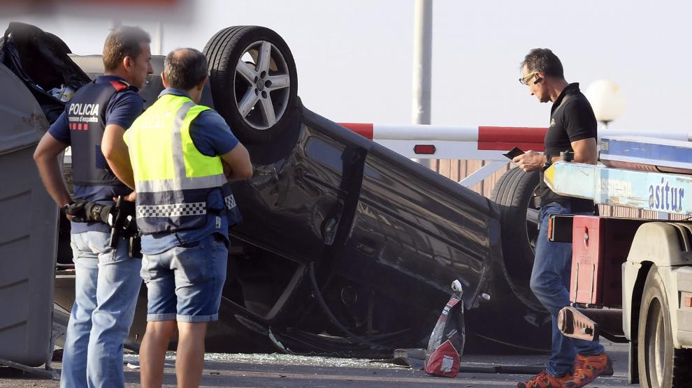 Agentes de los Mossos d'Esquadra examinan el vehículo Audi A3 donde iban los cinco terroristas, en el paseo marítimo de Cambrils.