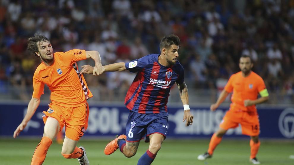 Eugeni, a la izquierda, le disputa el balón a Luso en el Huesca-Lorca de la pasada temporada.