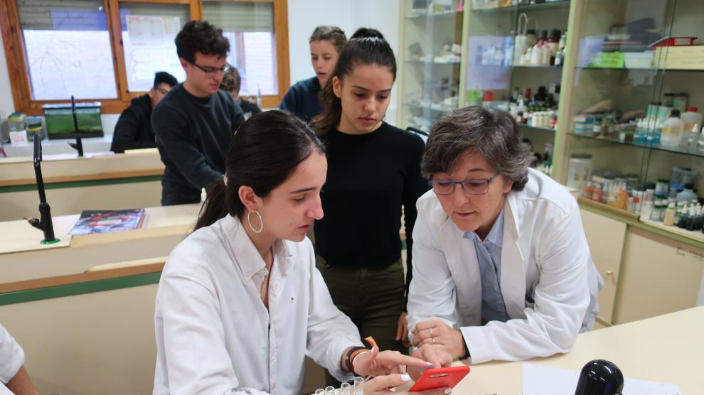 Olga Villagrasa, con sus alumnos de 1º de Bachillerato en el laboratorio, en una práctica con móviles.