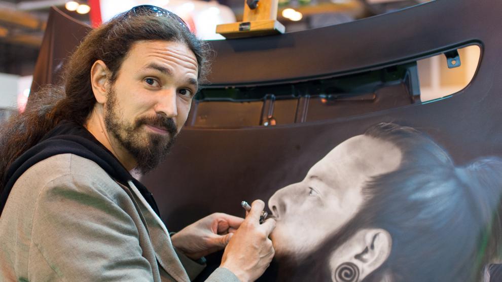 El artista oscense David Gatta, pintando con aerógrafo un capó.