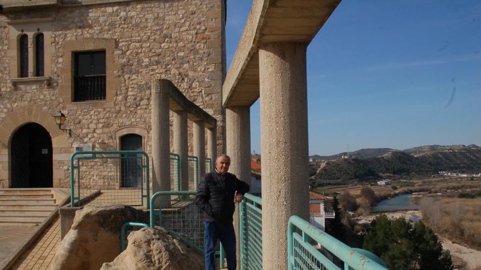 El alcalde de Nonaspe, Joaquín Llop, en un rincón de la localidad, con el ayuntamiento al fondo.