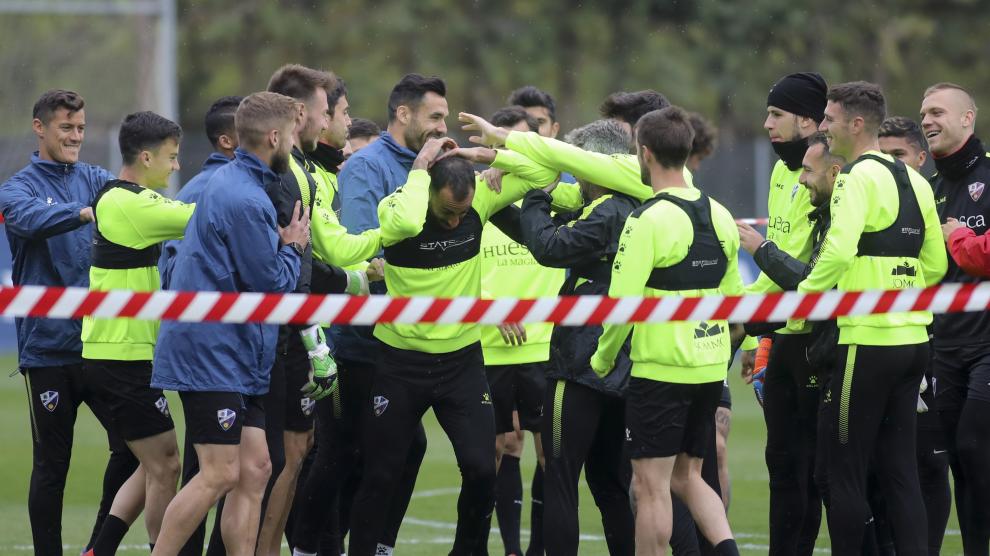 Carlos Akapo recibe una lluvia de collejas como recibimiento del equipo tras su lesión.