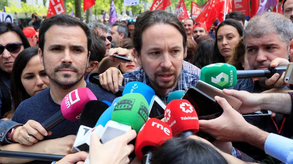 El secretario general de Podemos, Pablo Iglesias (c), en presencia del líder de IU, Alberto Garzón (i), hace declaraciones a los medios antes de participar en la manifestación convocada en Madrid con motivo del Primero de Mayo