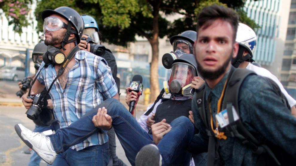 Un periodista herido en las protestas es trasladado por varias personas en Caracas