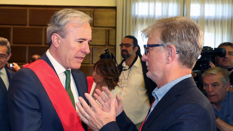 Pedro Santisteve conversa con el nuevo alcalde, Jorge Azcón, tras el pleno de constitución del Ayuntamiento de Zaragoza.