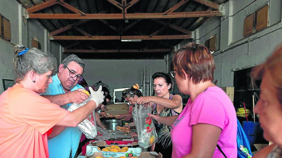 Varios vecinos preparan bolsas con comida y bebida para el operativo de extinción.