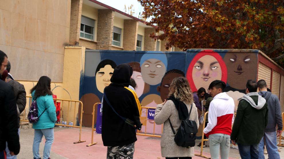 Varios vecinos contemplan una de las intervenciones artísticas llevadas a cabo en el barrio en 2018
