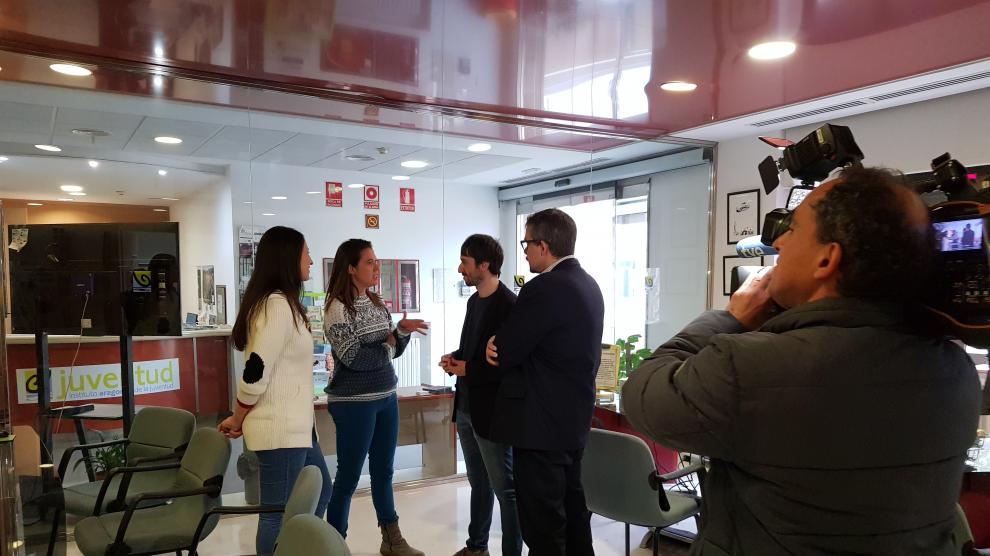 Dos de las jóvenes aragonesas que han retornado gracias al plan del Gobierno aragonés, Marta Mancebón y Ana Omeya, hablando con los directores gerentes del IAJ y del Inaem, Adrián Gimeno y Raúl Camarón.