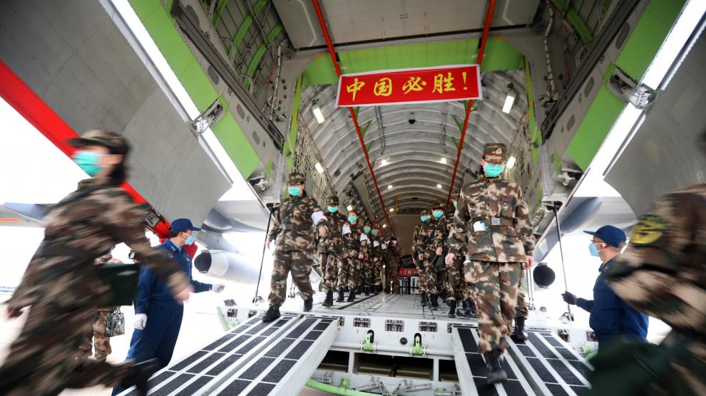 El personal médico llega con suministros médicos en un avión de transporte de la Fuerza Aérea del Ejército Popular de Liberación de China al aeropuerto Internacional de Wuhan