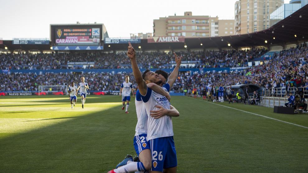 Luis Suárez, de rodillas, mira al cielo mientras es abrazado por Burgui.
