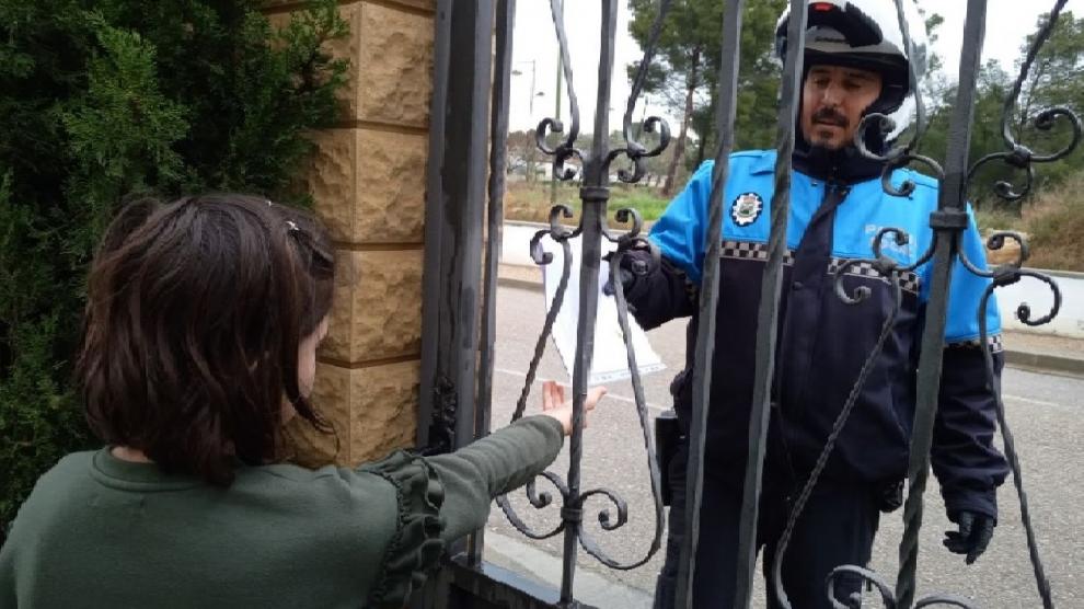 Vicente Sierra, Policía Local de Escatrón, entregando una bolsa de deberes.