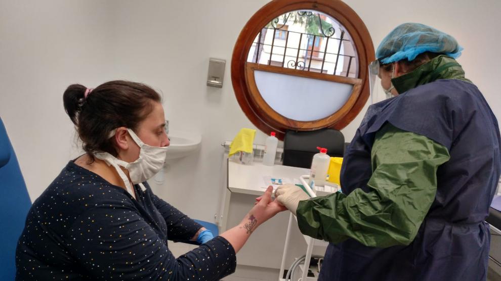 Una enfermera realiza un test rápido de coronavirus a una vecina en Utrillas