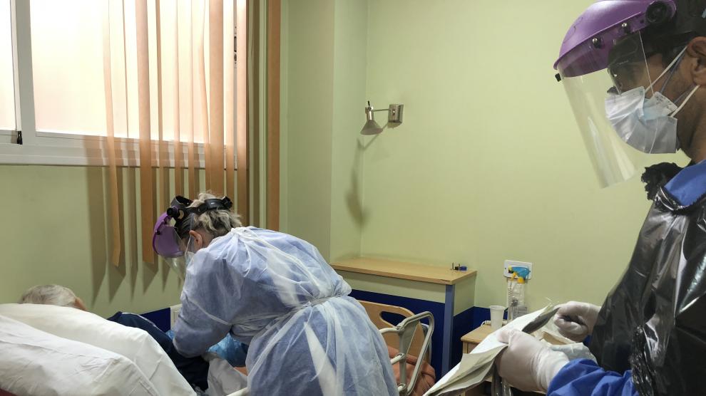 Una doctora y un enfermero atienden a un anciano con coronavirus