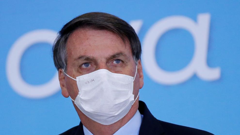 FILE PHOTO: Brazil's President Jair Bolsonaro wearing a protective mask looks on during the launching ceremony of the Plano Safra 2020/2021, action plan for the agricultural sector, in Brasilia
