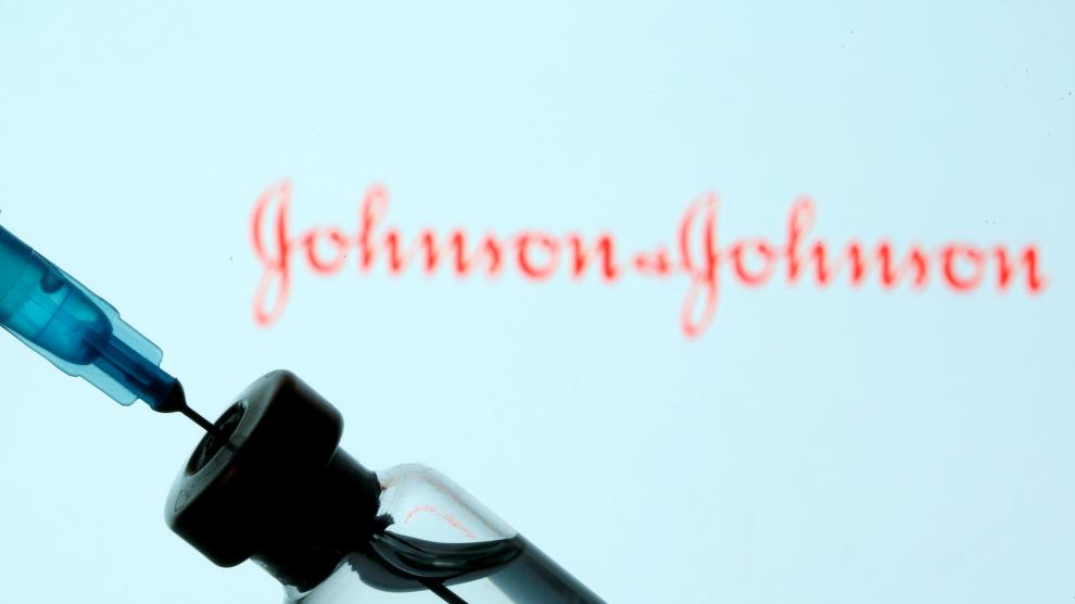 FILE PHOTO: Vial and syringe are seen in front of displayed Johnson&Johnson logo in this illustration