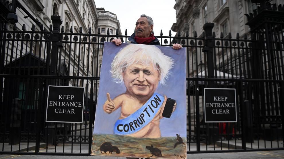 El dibujante satírico Kaya Mar, con una caricatura de Johnson delante de la residencia oficial del primer ministro