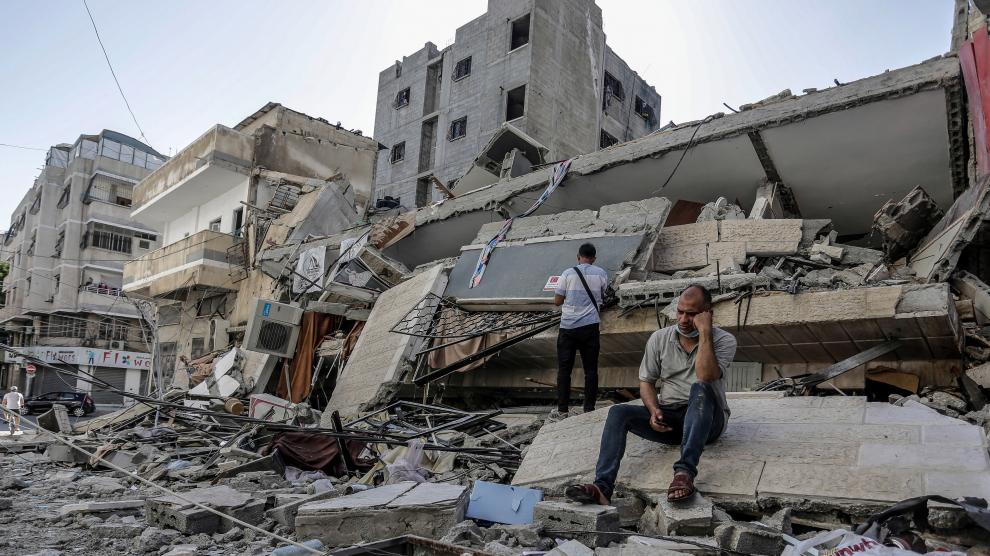 Un hombre junto a edificios destruidos por los bombardeos israelíes.