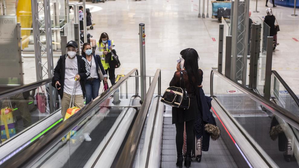 Pasajeros con mascarillas en las instalaciones del aeropuerto de Barajas.