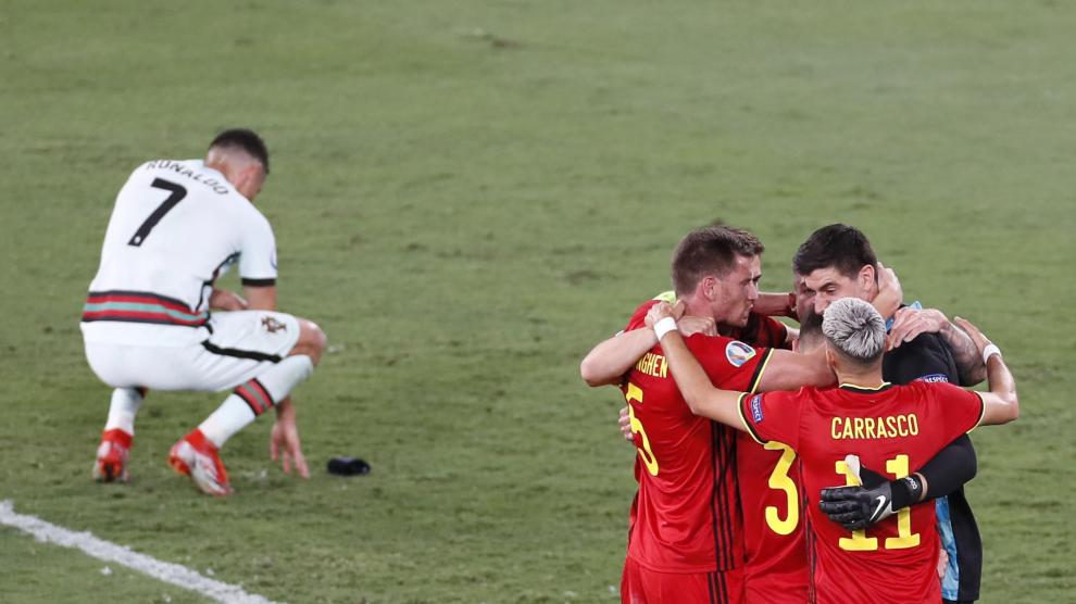 Cristiano Ronaldo se lamenta en el suelo mientras los jugadores de Bélgica celebran el triunfo