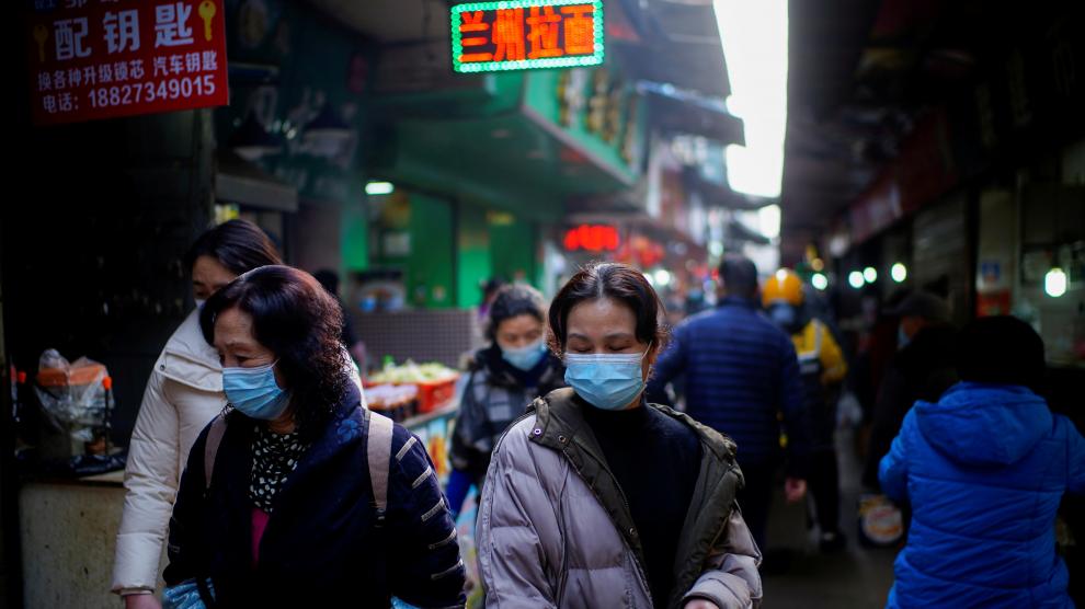 Gente con mascarillas por la calle del mercado de Wuhan donde arrancó la pandemia