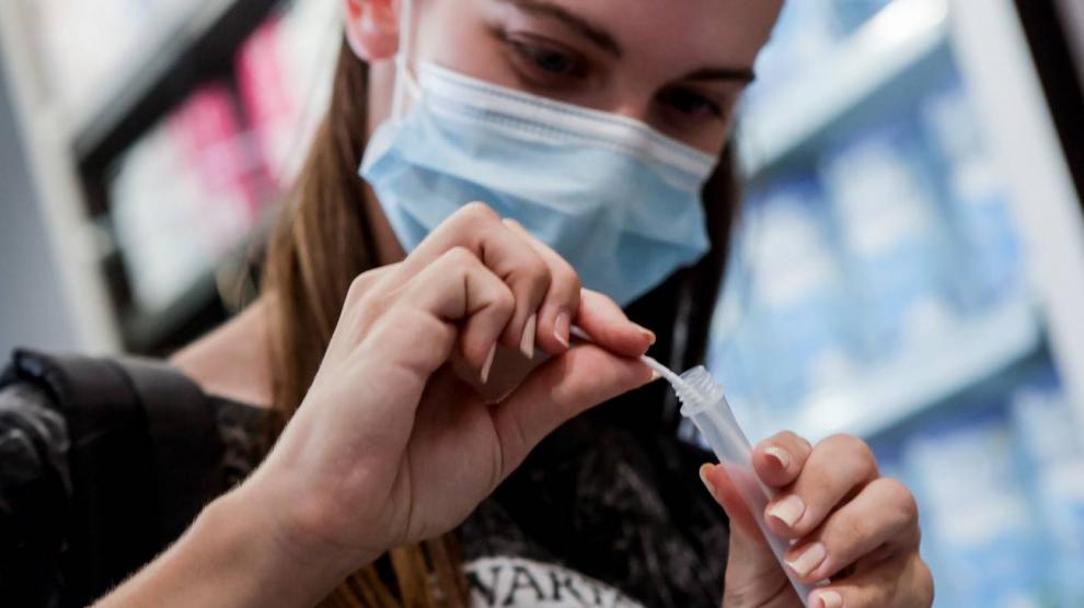Una mujer prueba un autotest de antígenos en una farmacia