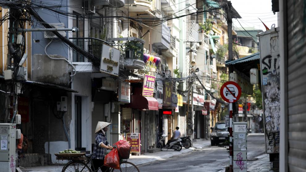 Un hombre con mascarilla circula por las calles de Hanoi