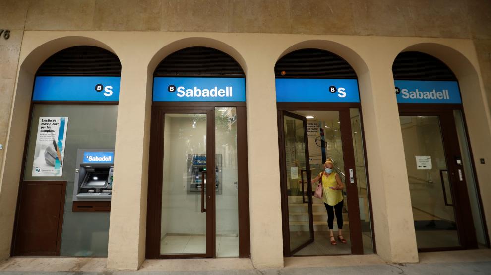 A woman leaves a Sabadell bank office in Barcelona
