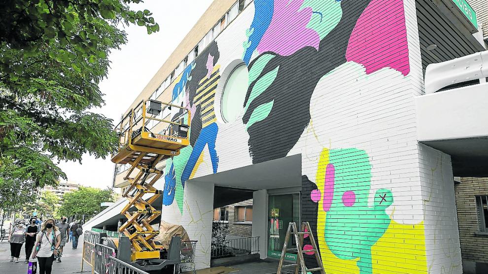 Proceso de creación del gran mural que plasman los artistas en la fachada del Infantil