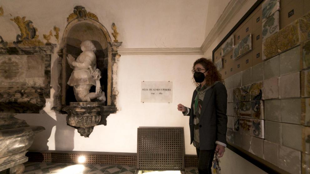 Susana Villacampa, conservadora del Museo Diocesano, frente a la tumba de Félix de Azara. En la imagen se puede ver el acceso a la subcripta, donde aparecieron sus huesos junto a otros restos humanos.