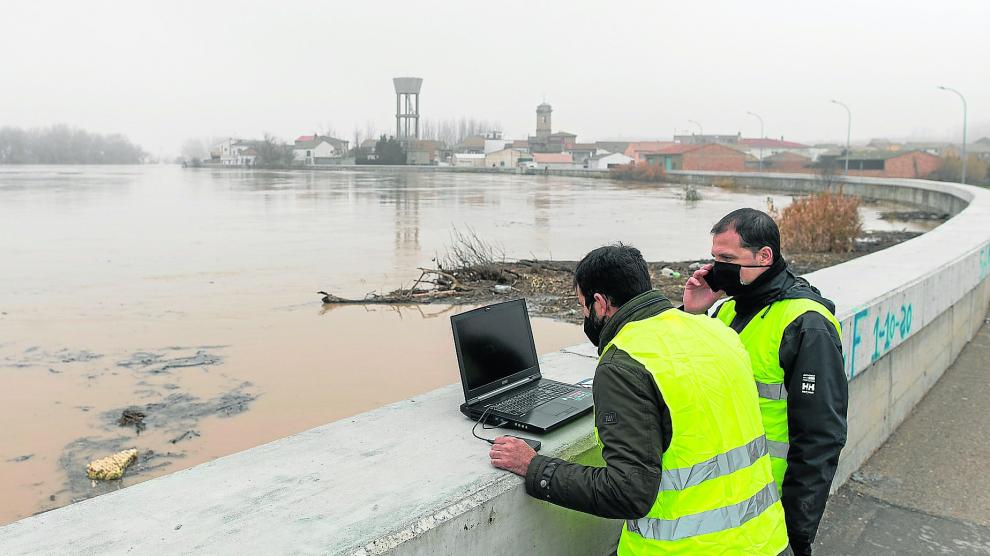 Dos técnicos de la CHE siguen la crecida en Cabañas y analizan en el ordenador modelizaciones del comportamiento del río.