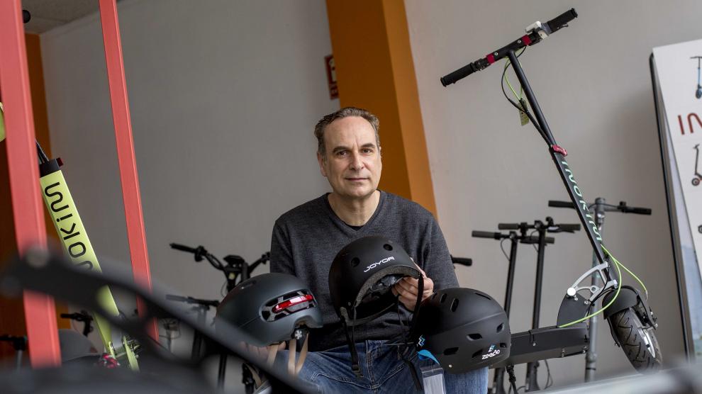 Juan Pérez, propietario de Eco Rider Shop, muestra varios modelos de cascos para patinetes.