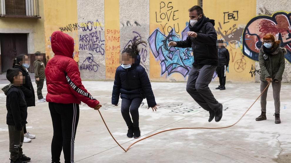 El educador Adrián Bailach salta a la comba con algunos de sus pequeños en el Arrabal.