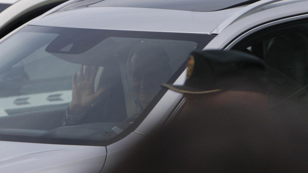 Juan Carlos I saluda desde el interior del vehículo tras aterrizar en España.