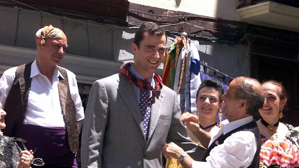 Un miembro de una peña bilbilitana de jota aragonesa coloca un cachirulo al príncipe Don Felipe de Borbón durante su visita a Calatayud.
