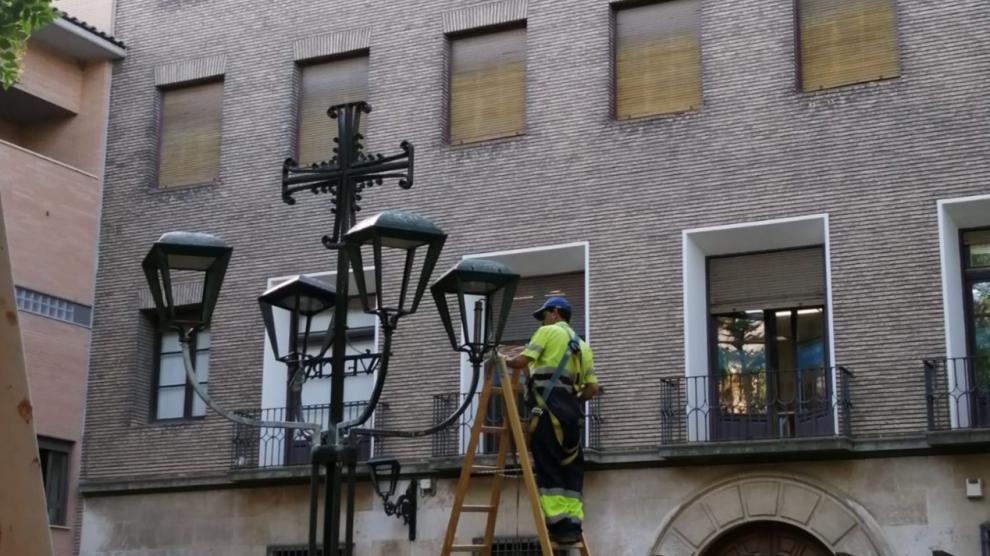 Los trabajadores preparan las conexiones eléctricas entre los brazos de la farola.