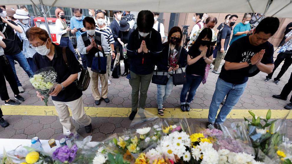 People offer flowers at the site where late former Japanese Prime Minister Shinzo Abe was shot while campaigning for a parliamentary election, near Yamato-Saidaiji station in Nara, Japan, July 9, 2022. REUTERS/Issei Kato JAPAN-ABE/