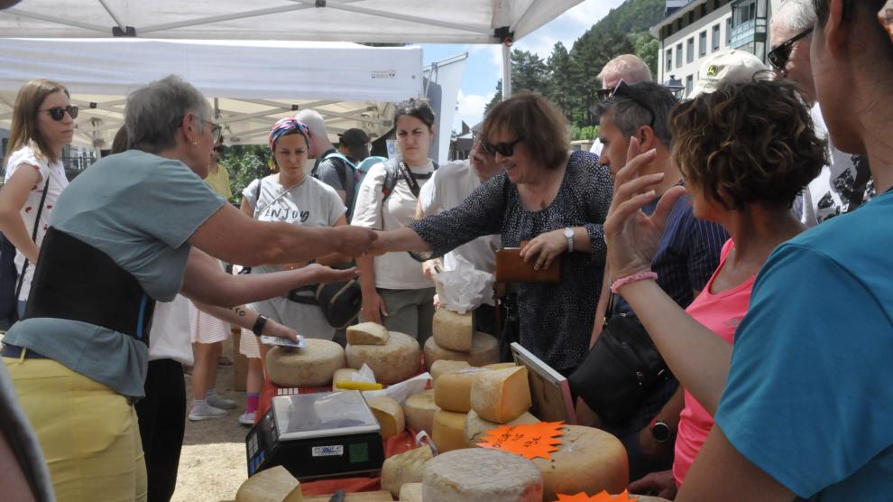 Una mujer compra queso en uno de los puestos de la feria.