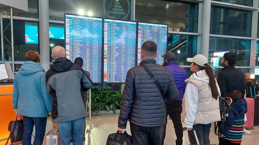 Varias personas comprueban el estado de sus vuelos en las pantallas del aeropuerto de Domodédovo en Moscú, Rusia.