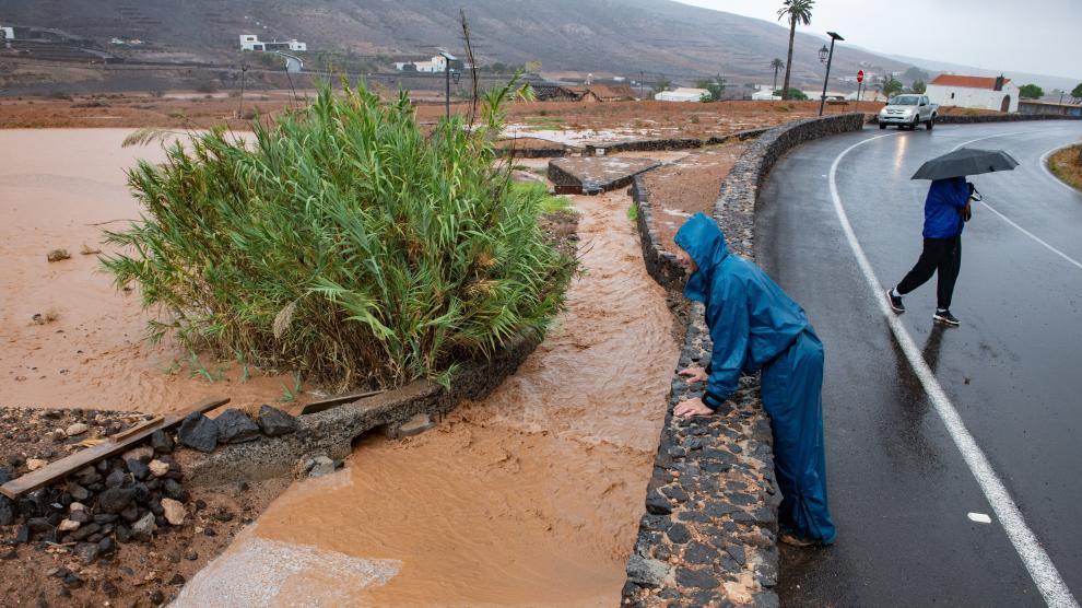 People watch from their homes a road flooded by the rain of the tropical storm Hermine, in Pozo Izquierdo, in the island of Gran Canaria, Spain, September 25, 2022. REUTERS/Borja Suarez EUROPE-WEATHER/SPAIN