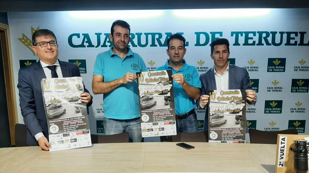 Los organizadores muestran el cartel anunciador de la concentración de coches clásicos en Teruel.