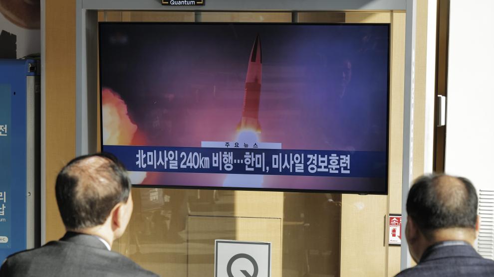 Dos ciudadanos ven imágenes del misil lanzado en una pantalla de televisión en Seúl