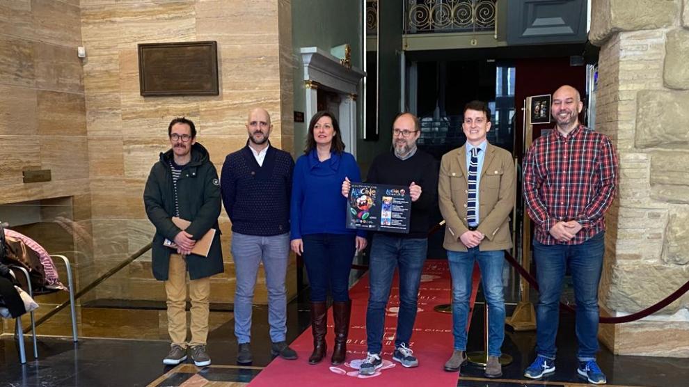 Los promotores y colabores del Festival Alucine posan sobre la alfombra roja con la que se recibirá a los espectadores.