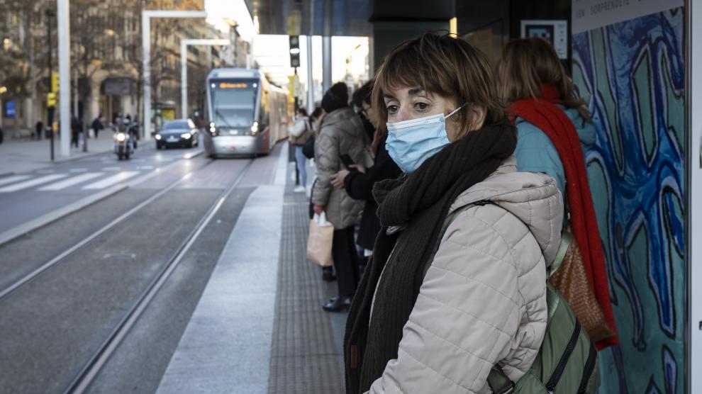 Varios pasajeros esperan el tranvía, este jueves, en el paseo de la Independencia de Zaragoza con la mascarilla puesta